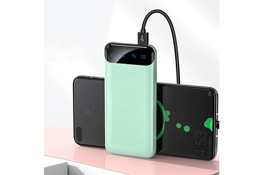 Portable power bank charging two smartphones, displaying battery levels on its LED screen